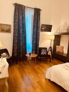 una camera da letto con un letto, un tavolo e delle sedie di La Gioconda Exclusive Suite a Bari