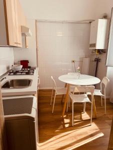una cucina con tavolo, sedie e lavandino di La Gioconda Exclusive Suite a Bari