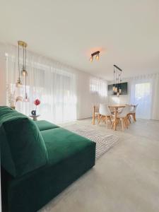 een woonkamer met een groene bank en een tafel bij Xzllenz - 4 Schlafzimmer, Zentral, Parken, U-Bahn, 2 Bäder, 4 Smart-TV, optional Einzelbett in Neurenberg