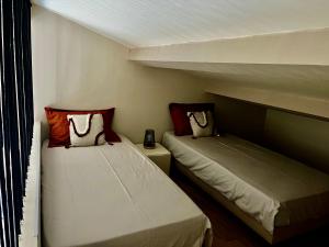 twee bedden in een kleine kamer met twee eenpersoonsbedden bij Le capèu in Mollégès