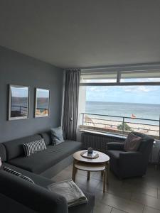 a living room with a couch and a table and a window at Strandhotel Wohnung 62 in Dahme
