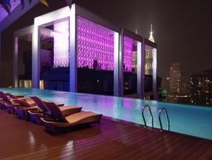 a pool on the roof of a building with chairs at Platinum suites klcc by Fifty One in Kuala Lumpur