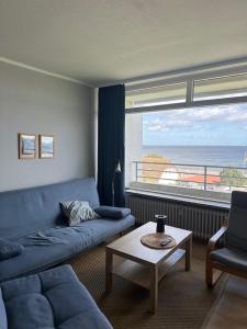 a living room with a blue couch and a table at Strandhotel Wohnung 48 in Dahme