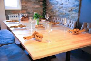 uma mesa de madeira com copos de vinho e guardanapos em Riverside Burabay Hotel em Borovoe