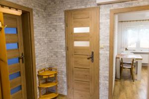 drewniane drzwi w pokoju ze stołem w obiekcie Domek Pod Klonem Agroturystyka w Białowieży