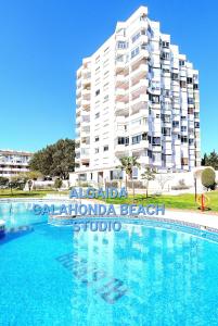 um grande edifício de apartamentos em frente a uma piscina em NUEVO! Algaida Calahonda Beach Studio em Sitio de Calahonda