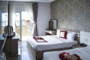 a hotel room with two beds and a window at Tiến Anhh 1 in Da Lat