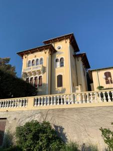 une grande maison avec une clôture blanche devant elle dans l'établissement Villa del Sorriso, à Castiglioncello