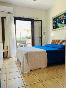 ein Schlafzimmer mit einem Bett und einem großen Fenster in der Unterkunft Villa LP Kokkino Chorio in Vamos