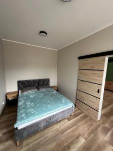 um quarto com uma cama grande e uma cómoda em madeira em Apartament Zamkowa 14 em Węgorzewo