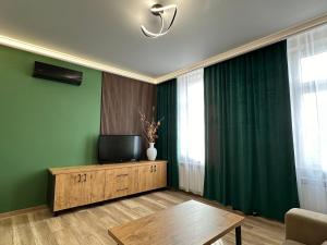 uma sala de estar com uma televisão e uma mesa em Apartament Zamkowa 14 em Węgorzewo