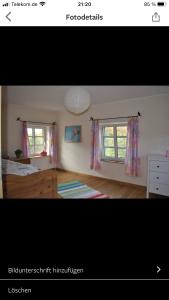 1 dormitorio con 2 ventanas, 1 cama y vestidor en Ferienhaus Wietsche, en Burscheid
