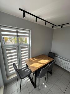 comedor con mesa de madera y sillas en Apartament Zamkowa 14, en Węgorzewo