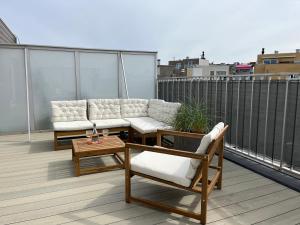 - un balcon avec deux canapés et une table sur le toit dans l'établissement Penthouse 29, à Ostende