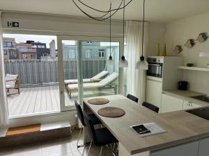 une cuisine et une salle à manger avec une table et un balcon dans l'établissement Penthouse 29, à Ostende