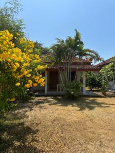 a house with yellow flowers in front of it at Samui Garden Resort in Bang Rak Beach