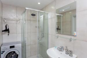 y baño con ducha, lavabo y lavadora. en Cozy Studio Ski In Out Apartment In New Gudauri en Gudauri