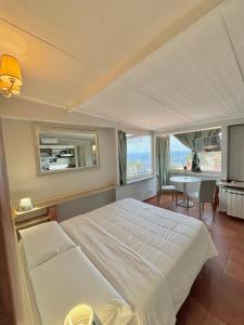 een slaapkamer met een groot wit bed en een tafel bij Villa Athèna in Taormina