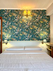 um quarto com uma cama com papel de parede floral em Villa Athèna em Taormina