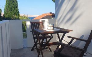ein Holztisch und zwei Stühle auf einer Terrasse in der Unterkunft Apartmani Sara Marija in Karlobag + 47 Fotos