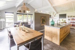 una cocina con una gran mesa de madera y un fregadero en Liefkeshoek, en Cuijk