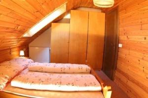 um quarto com 2 camas num quarto de madeira em Ferienwohnung für 4 Personen ca 50 qm in Bleiburg, Kärnten Unterkärnten em Bleiburg