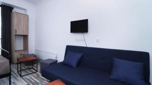 a living room with a blue couch and a tv at Ski In Out Apartment In New Gudauri For 4 in Gudauri