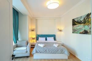 1 dormitorio con 1 cama y 1 silla en Apartment Alpic 204- Near Ski Lift - By Wehost en Gudauri