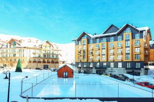 a large building with a rink in the snow at Apartment Alpic 204- Near Ski Lift - By Wehost in Gudauri
