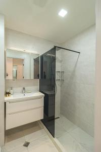y baño con lavabo y ducha acristalada. en Apartment Alpic 204- Near Ski Lift - By Wehost, en Gudauri
