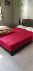ein großes Bett mit einer roten Decke darüber in der Unterkunft Sobey Laris Homestay Pasir Mas Town in Pasir Mas