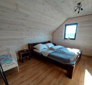 a bedroom with a bed in a wooden room at Domek Kaszubski Chill z balią ogrodową in Łąkie +28 photos