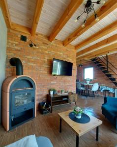 a living room with a brick wall with a fireplace at Domek Kaszubski Chill z balią ogrodową in Łąkie