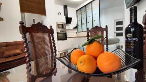 a bowl of oranges on a table with a bottle of wine at Reina in Valencia