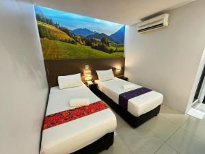 two beds in a room with a painting on the wall at Best View Hotel Puchong in Puchong