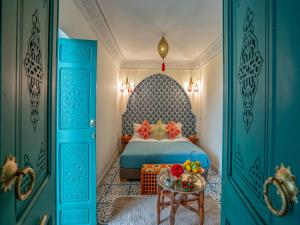 een slaapkamer met een bed en een tafel met bloemen erop bij Riad dar dada&spa in Marrakesh