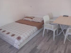 een slaapkamer met een bed en een tafel en stoelen bij Apartment Hristef in Ljubaništa