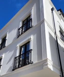a white building with balconies and a blue sky at Old Town Villa in Durrës