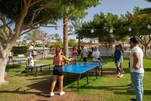 a group of people playing ping pong in a park at Desert Rose Resort in Hurghada