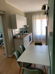 una cucina con tavolo bianco e sedie verdi di CentruMassimo Apartment a Palermo