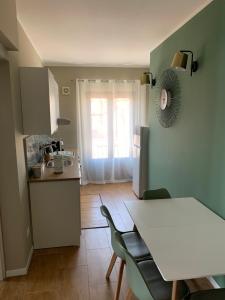 una cucina con tavolo e sedie bianchi di CentruMassimo Apartment a Palermo