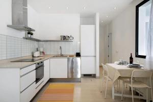 a kitchen with white appliances and a table with chairs at CASA ANCLADA en ARRIETA in Arrieta