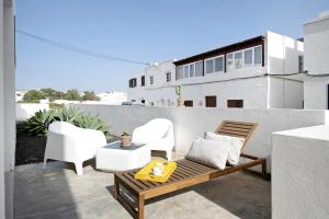 a patio with two white chairs and a wooden bench at CASA ANCLADA en ARRIETA in Arrieta