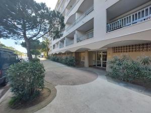 ein Gebäude mit einem Baum neben einem Bürgersteig in der Unterkunft La Sirène, à 250 m de la plage, T2 lumineux avec une terrasse spacieuse de15m² in Saint-Cyprien