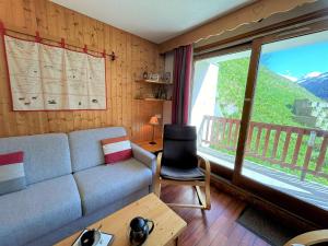 a living room with a couch and a large window at Appartement 2 pièces, 5 pers, Centre de Méribel, proche pistes, balcon Sud - FR-1-180-564 in Méribel
