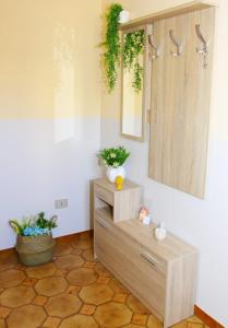 una stanza con cassettiera, specchio e piante di Largo Baluardo 13 ad Avola