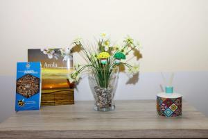 un vaso con dei fiori sul tavolo. di Largo Baluardo 13 ad Avola Altre 49 foto