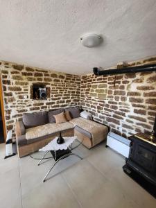 a living room with a couch and a brick wall at Authentic Mediterranean House with Postcard Sea View in Tivat