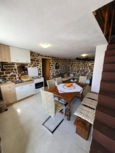 uma cozinha com mesa e cadeiras num quarto em Authentic Mediterranean House with Postcard Sea View em Tivat