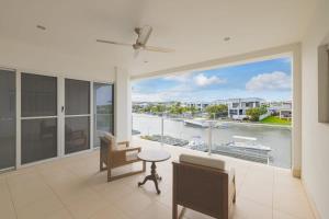 a living room with a large window with a view of a harbor at 3BR Serene Waterfront Retreat with pool & dock in Gold Coast